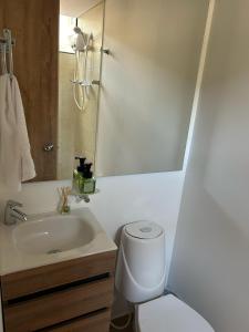 bagno con lavandino, servizi igienici e specchio di Apartamento Bogotá con vista a Monserrate a Bogotá