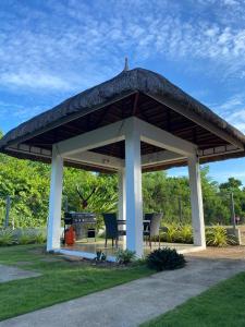 a pavilion with chairs and a grill in a park at Malipaj Apartments in Panglao Island