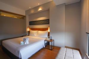 Ένα ή περισσότερα κρεβάτια σε δωμάτιο στο BATIQA Hotel Lampung