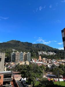 una città con edifici e montagne sullo sfondo di Apartamento Bogotá con vista a Monserrate a Bogotá
