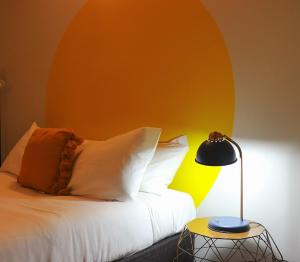 a bedroom with a bed with an orange wall at Wellington Hotel in Wellington