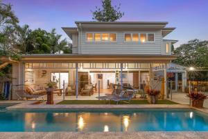 ein Haus mit einem Pool vor einem Haus in der Unterkunft Aaman & Cinta Luxury Villas in Byron Bay