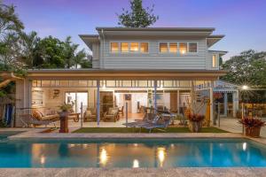a house with a swimming pool in front of a house at Aaman & Cinta Luxury Villas in Byron Bay