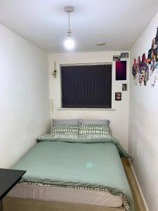 a small bedroom with a green bed in it at Private Room in shared Apartment Free Parking -20min to Manchester in Manchester