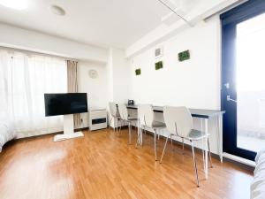Cette chambre dispose d'une table, de chaises et d'une télévision. dans l'établissement Park Hills East 23A / Vacation STAY 4384, à Sapporo