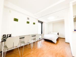 - une salle à manger avec des chaises blanches et un lit dans l'établissement Park Hills East 23A / Vacation STAY 4384, à Sapporo