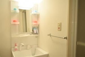 La salle de bains blanche est pourvue d'un lavabo et d'un miroir. dans l'établissement Park Hills East 23A / Vacation STAY 4384, à Sapporo