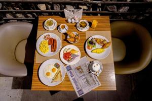 a table with breakfast foods on plates on it at Oakwood Residence Sukhumvit 24 - SHA Extra Plus in Bangkok