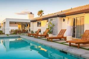 een villa met een zwembad en houten stoelen bij Resort style Villa w/ views, pool, spa and golf in Palm Springs