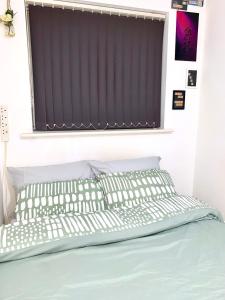 a bedroom with a bed with a window with a blind at Private Room in shared Apartment Free Parking -20min to Manchester in Manchester