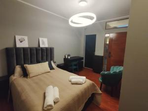 een slaapkamer met een groot bed en handdoeken bij La Casona Hostel in Cochabamba
