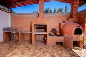 an outdoor brick oven with a table and a counter at La Casa de Luiz - Casa de Campo 