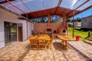 un patio con mesa de madera, sillas y horno de ladrillo en La Casa de Luiz - Casa de Campo, 