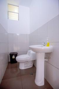 Baño blanco con lavabo y aseo en La Casa de Luiz - Casa de Campo, 
