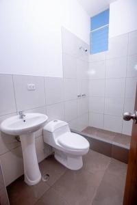 a white bathroom with a toilet and a sink at La Casa de Luiz - Casa de Campo 