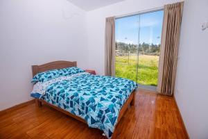 1 dormitorio con cama y ventana grande en La Casa de Luiz - Casa de Campo, 