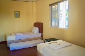 a room with two beds and a window at Hana-Natsu Resorts Pool & Hotel in Maybayo