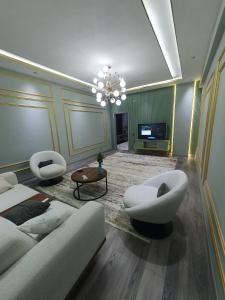 a living room with a couch and chairs and a television at Designed 2 rooms in Dushanbe