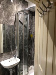 ein Bad mit einer Dusche und einem Waschbecken in der Unterkunft Yardley Lodge in Birmingham