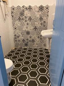 a bathroom with a black and white tiled wall at B2 Hotel Savannakhet in Savannakhet +47 photos