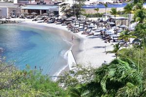 - une plage avec des chaises et des personnes assises sur la plage dans l'établissement Beachfront Cozy Apt, à Gros Islet