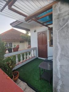 a patio with a wooden pergola and green grass at Hom Baan Chiang Mai in Chiang Mai