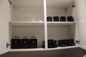 a white cabinet filled with dishes and plates at Modern 2 bed flat Southampton- Close to Central Station & Shops in Southampton