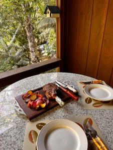 una mesa con un plato de comida en una mesa en Casa de campo com cachoeira no quintal, en Gaspar