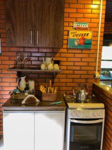 a kitchen with a stove and a counter top at Casa de campo com cachoeira no quintal in Gaspar