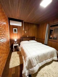 1 dormitorio con 1 cama blanca grande en una habitación en Casa de campo com cachoeira no quintal, en Gaspar