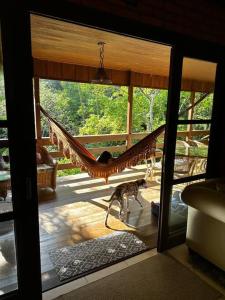 a hammock in a room with a view of a porch at Casa de campo com cachoeira no quintal in Gaspar