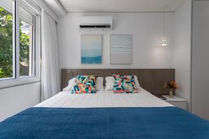 a bedroom with a large bed with a blue blanket at Fantastic sea view - Maison Ipanema Prime in Rio de Janeiro