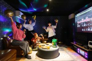 een groep mensen in een kamer met hun handen in de lucht bij 釜之宿 天王寺 in Osaka