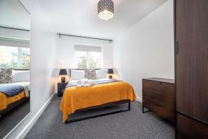 a bedroom with two beds and a dresser at A Stylish One-Bedroom Next to London Museum! in Colindale