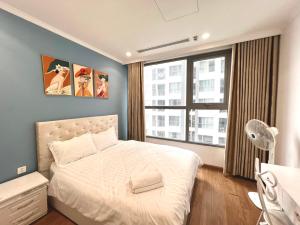 a bedroom with a white bed and a large window at BOM HOMES- VINHOMES TIMES CITY- 2BR- PARK hill in Hanoi +35 photos