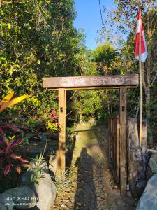 um sinal que diz jardineiro acolhedor com uma bandeira em CLOVE GARDEN em Gitgit