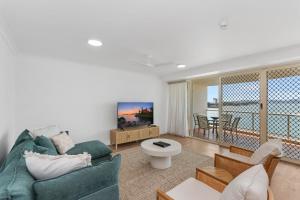 a living room with a couch and a balcony at Mariners North Holiday Apartments in Townsville