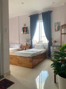 a bedroom with a large bed with blue curtains at Bonjour Hostel in Hue