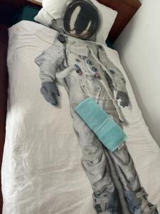 une personne en costume d'astronaute posant sur un lit dans l'établissement Mt Eden Tidy Bedroom rm7, à Auckland