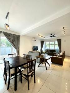 a dining room and living room with a table and chairs at Hom Villa 5rm 12-22 pax Wifi Netflix BBQ SteamBoat Games Beach Water Park in Kota Tinggi