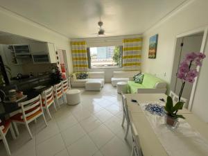 uma sala de estar com um sofá e uma mesa em Apartamento Maré Mansa a 30 metros da praia Mansa em Caiobá com Wifi em Caiobá