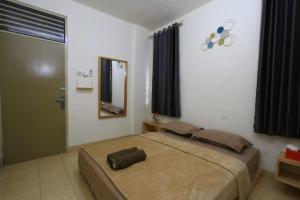 ein Schlafzimmer mit einem großen Bett und einem Spiegel in der Unterkunft Athala homestay syariah in Yogyakarta