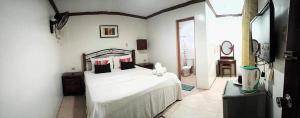 um quarto com uma grande cama branca num quarto em Double Diamond Inn Guest House em Boracay