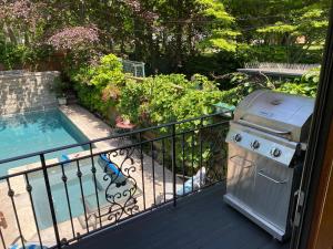 a grill on a balcony next to a swimming pool at Superb Beach Home:Heated Pool-Hot Tub Open 365Days in Toronto