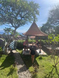 a woman walking up to a gazebo at Poling sea view in Batununggul +5 photos