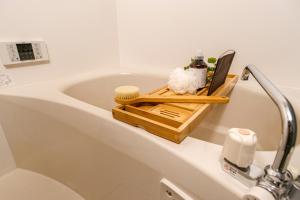 bañera con bandeja de madera. en Premium Apartment Hotel Tokyo East en Tokio