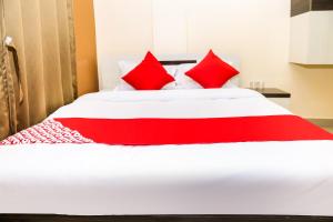 a red and white bed with red pillows on it at OYO Hotel Sonar Gaon in Agartala