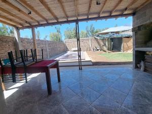 un patio con mesa, sillas y chimenea en Cabaña Rincón Escondido en Maipú