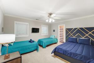 een slaapkamer met 2 bedden en een plafondventilator bij Uptown Luxe W King Suite & Hot Tub Sleeps 20 in Charlotte