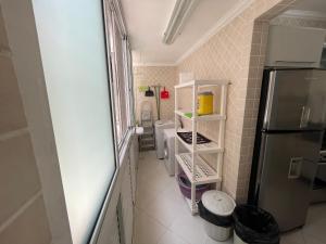 a small kitchen with a refrigerator and a sink at Apartamento Maré Mansa a 30 metros da praia Mansa em Caiobá com Wifi in Caiobá +38 photos
